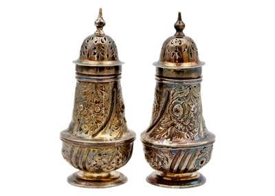 Lot 96 - A pair of Victorian silver foliate embossed pepper casters by Josiah Williams & Co.