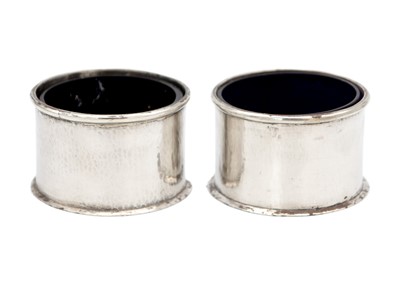 Lot 138 - A pair of modern planished silver salts with blue glass liners.