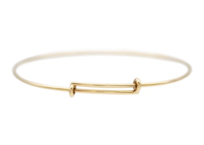 Lot 25 - A Tiffany & Co 9k gold adjustable wire bangle.