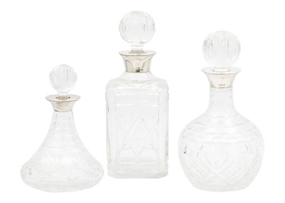 Lot 184 - Three modern silver-rimmed cut glass decanters by Camelot Silverware Ltd.