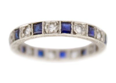 Lot 84 - A 9k white gold synthetic sapphire and CZ eternity ring.