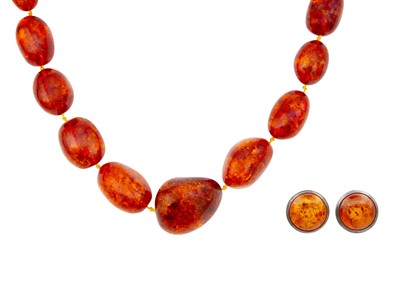 Lot 13 - A large graduated heat-treated cognac amber bead necklace with a pair of earrings.