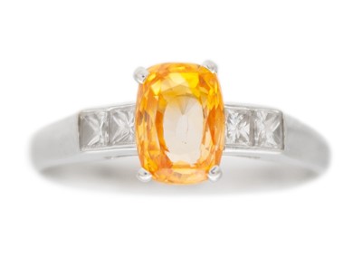 Lot 6 - A peach sapphire and diamond 18k white gold ring.