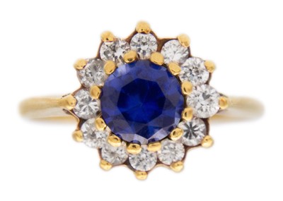 Lot 45 - A 9k gold synthetic sapphire and CZ halo ring.