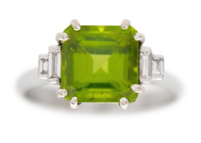 Lot 100 - A square emerald-cut peridot and diamond 18k white gold ring.