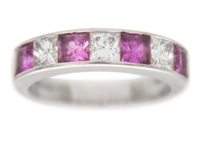 Lot 102 - A pink sapphire and diamond channel set 18k white gold band ring.