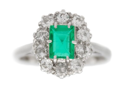 Lot 4 - An emerald and diamond white gold cluster ring.