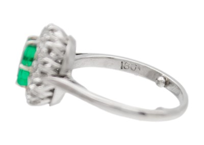 Lot 4 - An emerald and diamond white gold cluster ring.