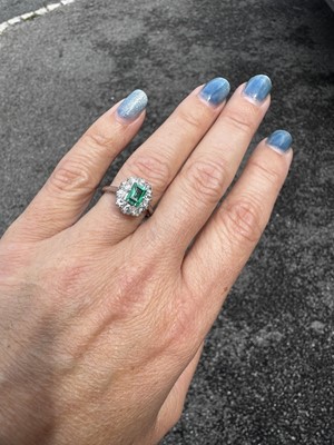 Lot 105 - A good 0.75ct emerald and diamond set 18k white gold cluster ring.