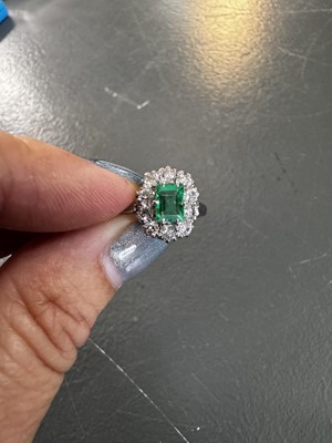 Lot 105 - A good 0.75ct emerald and diamond set 18k white gold cluster ring.
