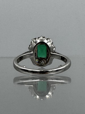 Lot 105 - A good 0.75ct emerald and diamond set 18k white gold cluster ring.