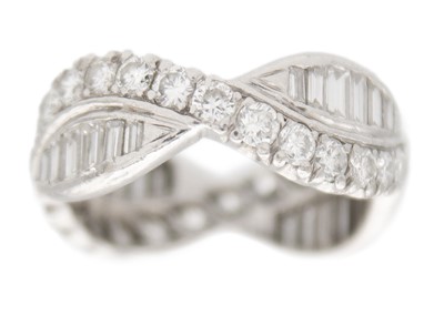 Lot 11 - A diamond fancy crossover band ring in platinum.