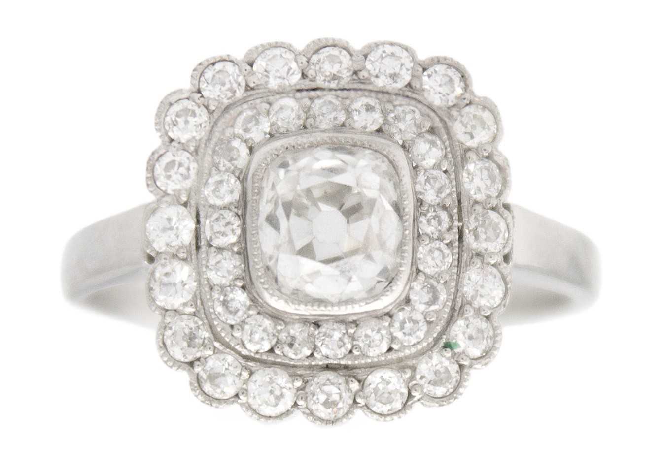 Lot 2 - An Art Deco old mine cut diamond cushion ring in platinum.