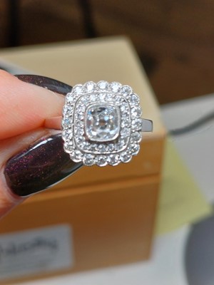 Lot 2 - An Art Deco old mine cut diamond cushion ring in platinum.