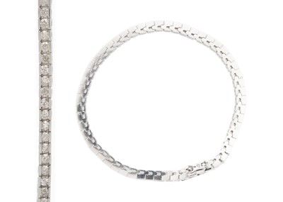 Lot 122 - A 14k white gold brilliant-cut diamond line bracelet.