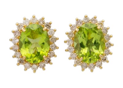 Lot 145 - A pair of 18k yellow gold peridot and diamond halo stud earrings.