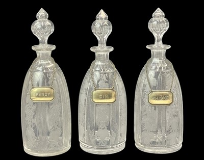 Lot 185 - A set of three Victorian engraved glass decanters and stoppers.