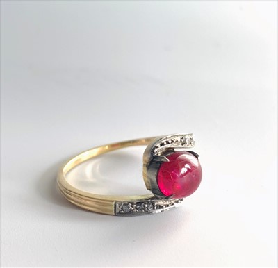 Lot 2570 - A cabochon ruby and diamond crossover ring.