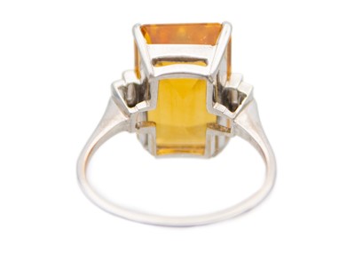 Lot 105 - An orange citrine and diamonds 18k white gold dress ring.
