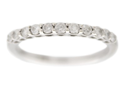 Lot 114 - A 9k white gold half-eternity diamond ring.