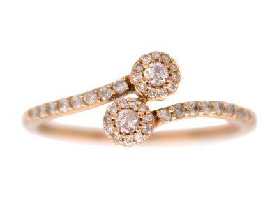 Lot 124 - A 9k rose gold pink and white diamond crossover style ring.