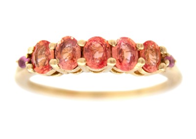 Lot 126 - A 9k gold five-stone pinkish-orange sapphire ring.