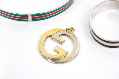 Lot 271 - GUCCI - A chrome plated and enamel belt form bracelet, choker, and a GG pendant.