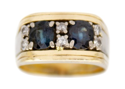 Lot 192 - A 14k yellow and white gold diamond and blue sapphire set band ring.