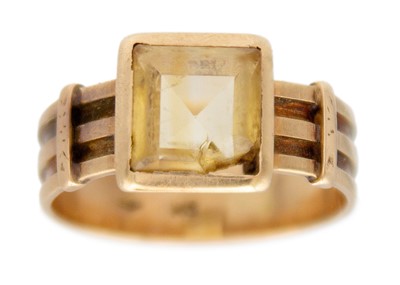 Lot 210 - A golden citrine solitaire band ring in 14K yellow gold.