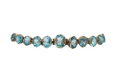 Lot 229 - A 9k rose gold graduated blue zircon bracelet.