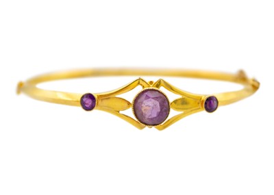 Lot 230 - An antique amethyst 9k yellow gold hollow bangle.