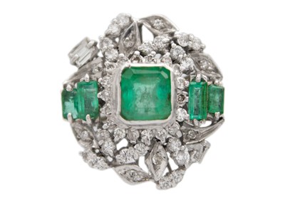 Lot 256 - A white gold diamond and emerald set ballerina ring.