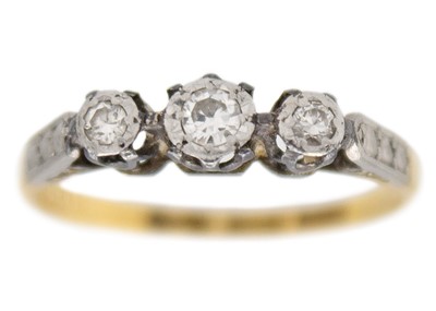 Lot 253 - An 18k gold and platinum three-stone diamond ring.