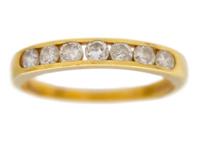 Lot 244 - An 18k yellow gold seven-stone diamond band ring.