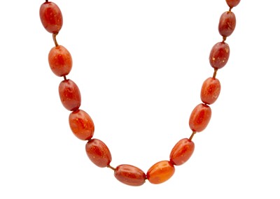 Lot 268 - A graduated dark opaque amber bead necklace.