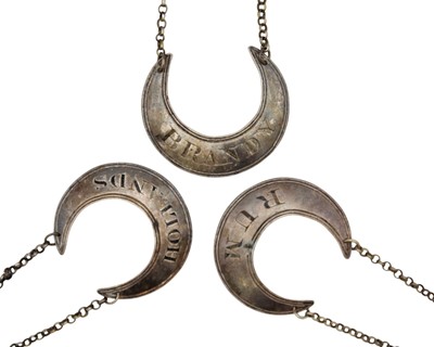Lot 214 - A George III silver set of three crescent-shaped spirit labels by Phipps, Robinson & Phipps.