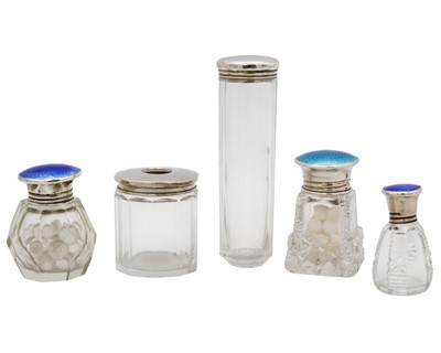 Lot 103 - A selection of five silver top glass dressing table bottles, three with enamel.