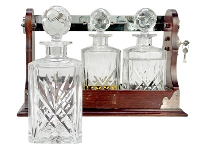 Lot 87 - A modern mahogany and silver plate three bottle tantalus.