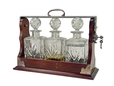 Lot 87 - A modern mahogany and silver plate three bottle tantalus.