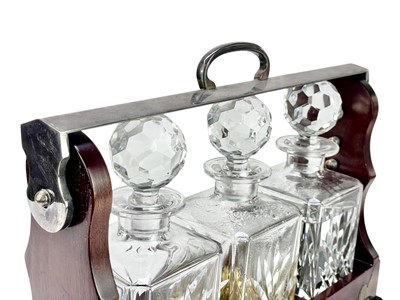 Lot 87 - A modern mahogany and silver plate three bottle tantalus.