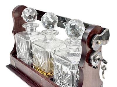 Lot 87 - A modern mahogany and silver plate three bottle tantalus.