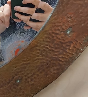 Lot 840 - An Arts and Crafts oval copper mirror.