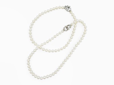 Lot 80 - A two-strand white cultured pearl interchangable necklace with silver clasps by Chow Tai Fook.