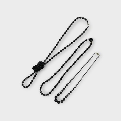 Lot 118 - Three faceted and round jet bead necklaces.