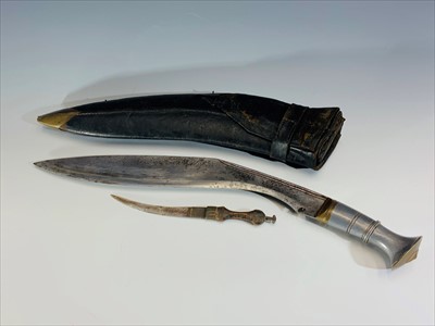 Lot 207 - A Kukri with polished metal grip, etched blade...