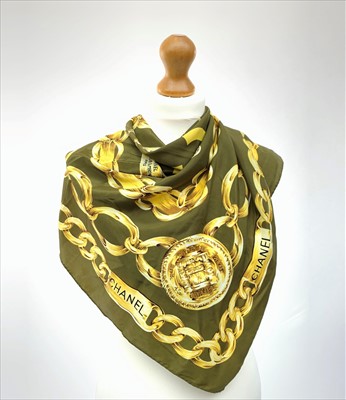 Lot 3083 - A silk scarf by Chanel, in olive green with...
