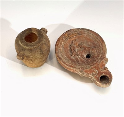 Lot 219 - A terracotta oil lamp, probably Roman, moulded...
