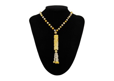 Lot 119 - A Chinese jade bead necklace, with carved fish design cylindrical pendant, applied with tassels.