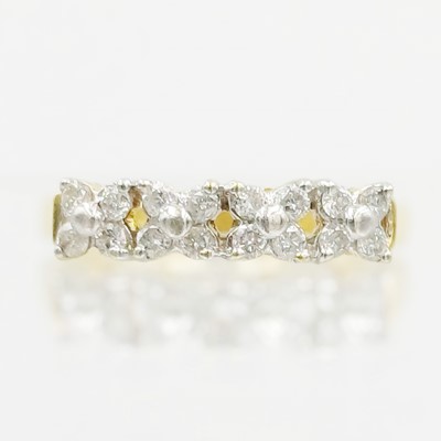 Lot 125 - An 18k gold and diamond cluster band ring.