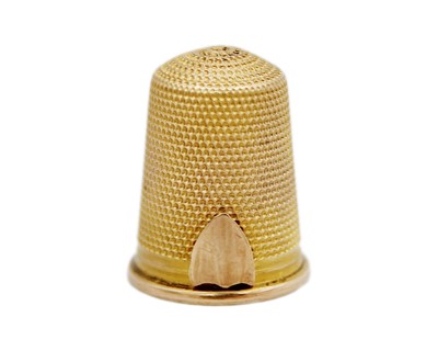 Lot 153 - A gold thimble, testing as 14k, with fine dimpling and vacant shield cartouche.